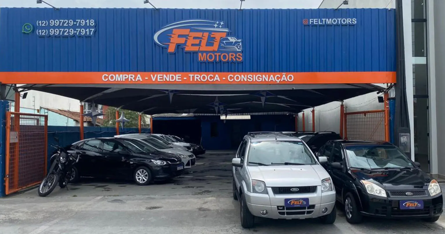 Fachada azul e laranja da Felt Motors em Taubaté, com os veículos no pátio